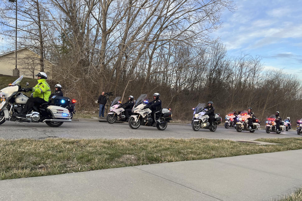 More than a dozen officers line up to escort the bodies of an Independence, Mo., police officer and a Jackson County court worker to the medical examiner's office, Thursday, Feb. 29, 2024, in Independence. Officer Cody Allen and process server Drexel Mack were fatally shot Thursday after Mack tried to serve an eviction notice. (AP Photo/Heather Hollingsworth)