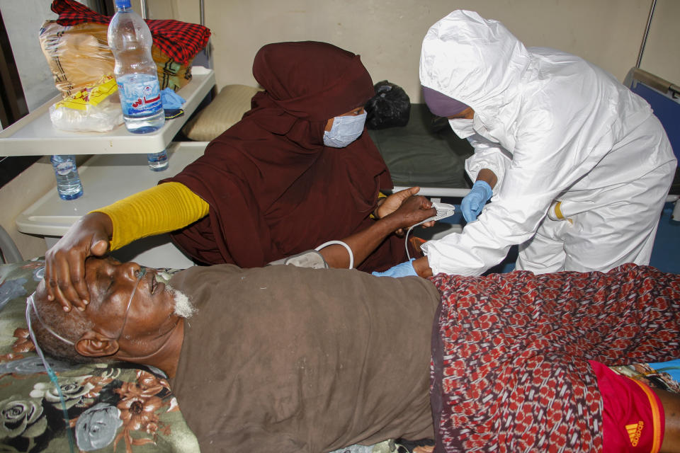 A doctor tends to a patient on oxygen suffering from COVID-19 in a ward for coronavirus patients at the Martini hospital in Mogadishu, Somalia on Wednesday, Feb. 24, 2021. A crisis over the supply of medical oxygen for coronavirus patients has struck in Africa and Latin America, where warnings went unheeded at the start of the pandemic and doctors say the shortage has led to unnecessary deaths. (AP Photo/Farah Abdi Warsameh)