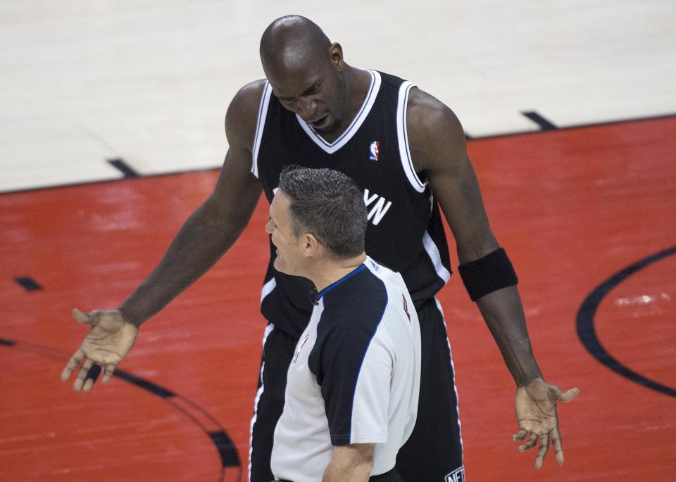 Brooklyn Nets forward Kevin Garnett, back, argues with referee Monty McCutchen during the first half of Game 2 in an NBA basketball first-round playoff series against the Toronto Raptors, Tuesday, April 22, 2014, in Toronto. (AP Photo/The Canadian Press, Nathan Denette)