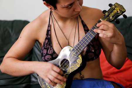 Roberta Vassallo, a member of the "Assemblea Cavallerizza 14:45" movement, plays a ukulele at the Cavallerizza Reale building, which is occupied by the movement in Turin, Italy July 20, 2016. REUTERS/Marco Bello
