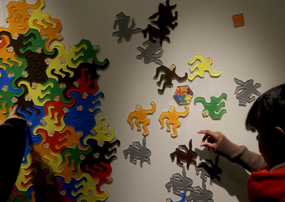 Students play with interlocking shapes at a "Tessellation Station" at the new National Museum of Mathematics in New York, Monday, Dec. 17, 2012. The museum is aimed at kids aged 8 to 13, and curators have given the place a playground feel. The 40 exhibits include a "wall of fire" made up of laser lights that teaches kids about geometry and a square-wheeled tricycle that still manages to produce a smooth ride thanks to a wavy track. (AP Photo/Seth Wenig)