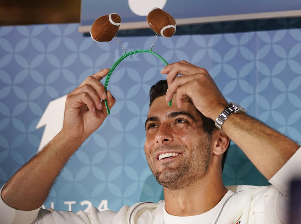 San Francisco 49ers' Jimmy Garoppolo puts a football hairband during Opening Night for the NFL Super Bowl 54 football game Monday, Jan. 27, 2020, at Marlins Park in Miami. (AP Photo/David J. Phillip)