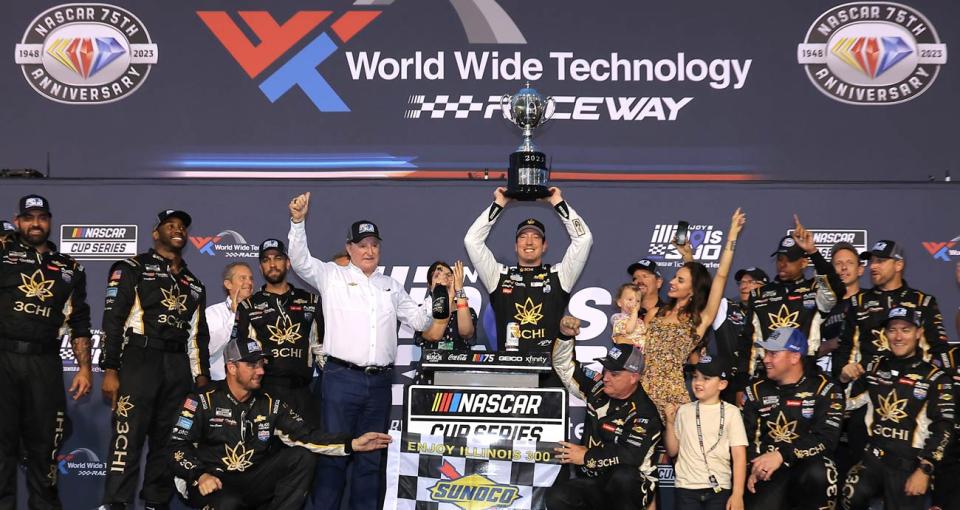 Kyle Busch hoists the trophy and celebrates in Victory Lane at World Wide Technology Raceway.