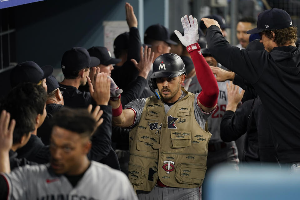 Minnesota Twins' Trevor Larnach, center, celebrates in the dugout after hitting a home run during the eighth inning of a baseball game against the Los Angeles Dodgers in Los Angeles, Monday, May 15, 2023. Byron Buxton and Jorge Polanco also scored. (AP Photo/Ashley Landis)