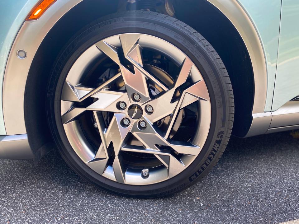 The 21-inch wheel alloy wheel at the right front corner of a 2024 Genesis GV60 EV.