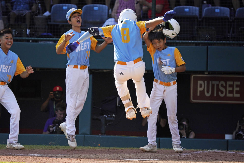 Honolulu's Rustan Hiyoto (8) leaps onto home plate after hitting a two-run home run off Nolensville, Tenn.'s Trent McNeil in the fourth inning of the United State Championship baseball game at the Little League World Series tournament in South Williamsport, Pa., Saturday, Aug. 27, 2022. (AP Photo/Gene J. Puskar)