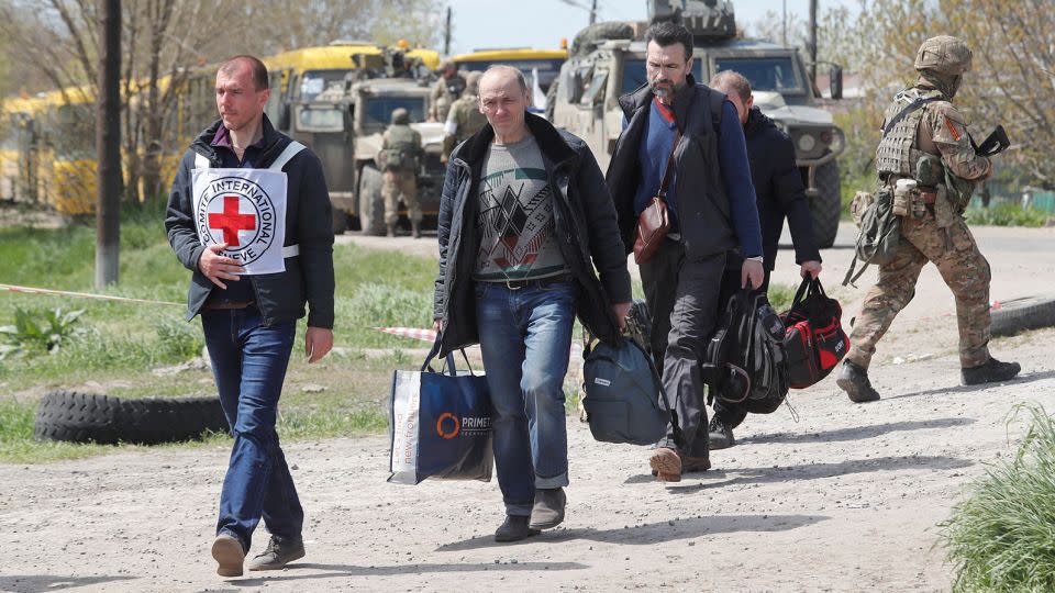 Civilians are accompanied by members of the Red Cross to the village of Bezimenne in the Donetsk Region, Ukraine. - Alexander Ermochenko/Reuters