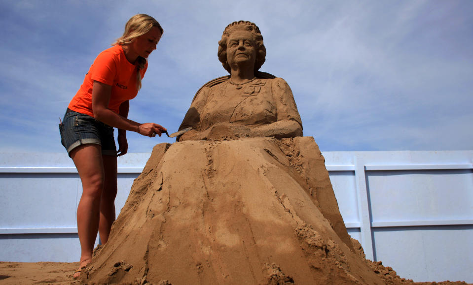 WESTON-SUPER-MARE, ENGLAND - MAY 28: Sand sculpture artist Nicola Wood completes a sand sculpture she has created of Queen Elizabeth II at the annual Weston-super-Mare Sand Sculpture festival on May 28, 2012 in Weston-Super-Mare, England. Now in its seventh year, the festival, which opens to the public on Friday, features sand sculptures from award-winning artists from across the globe. Using 4000 tonnes of Weston beach sand this year's giant sand art display, created by 15 international artists on the theme Fun and Games, runs throughout the summer until September 9. (Photo by Matt Cardy/Getty Images)