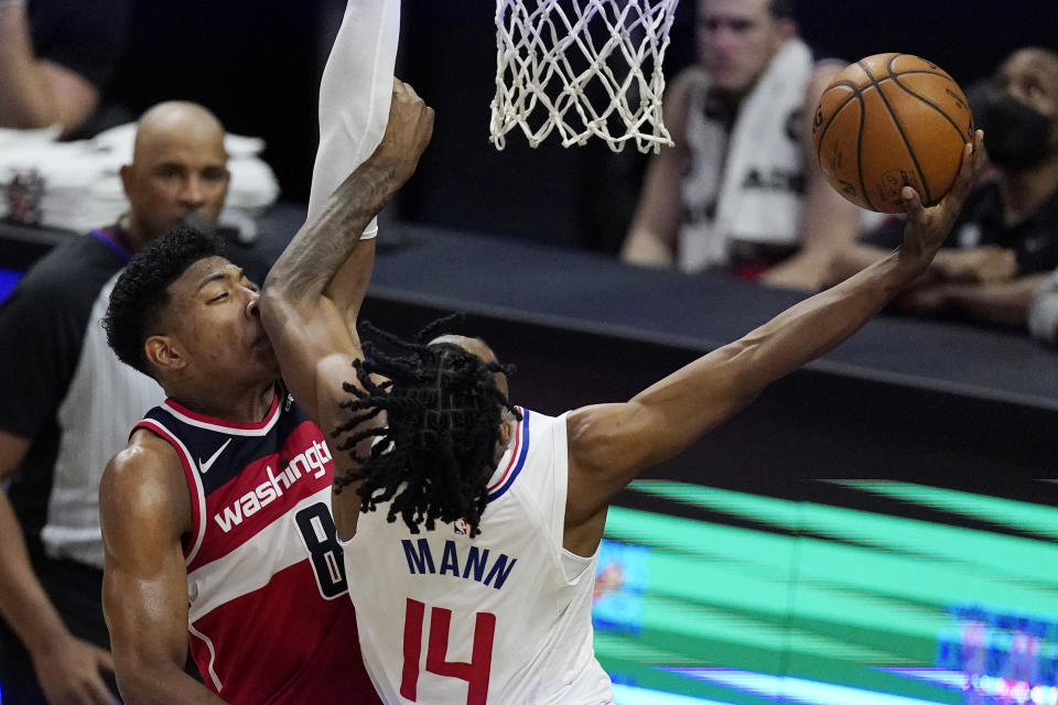 Los Angeles Clippers guard Terance Mann, right, elbows Washington Wizards forward Rui Hachimura on the face as he shoots during the second half of an NBA basketball game Tuesday, Feb. 23, 2021, in Los Angeles. The Clippers won 135-116. (AP Photo/Mark J. Terrill)