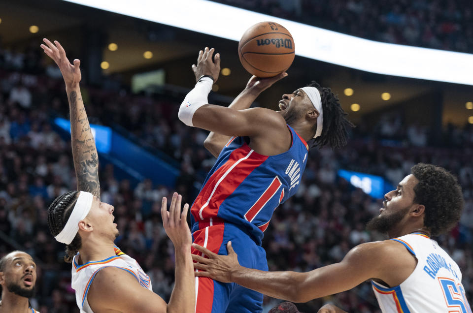 Detroit Pistons' Stanley Umude shoots from between Oklahoma City Thunder's Lindy Waters III, left, and Jeremiah Robinson-Earl (50) during the second half of an NBA preseason basketball game Thursday, Oct. 12, 2023, in Montreal. (Christinne Muschi/The Canadian Press via AP)