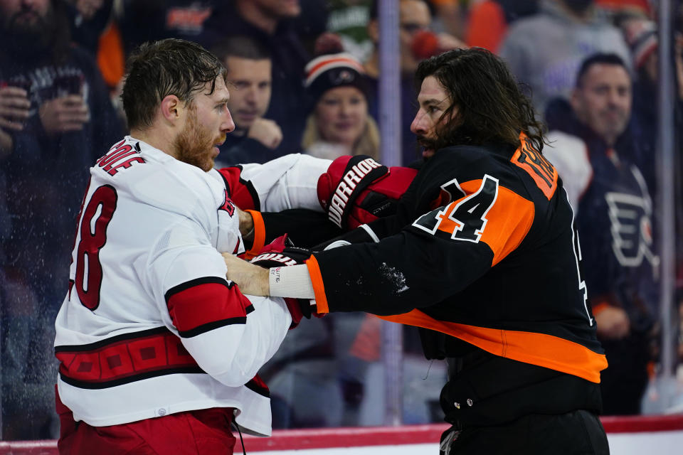 Carolina Hurricanes' Ian Cole, left, and Philadelphia Flyers' Nate Thompson wrestle during the second period of an NHL hockey game, Friday, Nov. 26, 2021, in Philadelphia. (AP Photo/Matt Slocum)