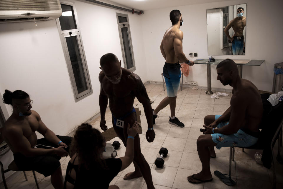 Contestants prepare backstage during the National Amateur Body Builders Association competition in Tel Aviv, Israel, Wednesday, Aug. 19, 2020. Because of the coronavirus pandemic, this year's competition was staged outdoors in Tel Aviv. The 85 participants were required to don protective masks in line with health codes. (AP Photo/Oded Balilty)