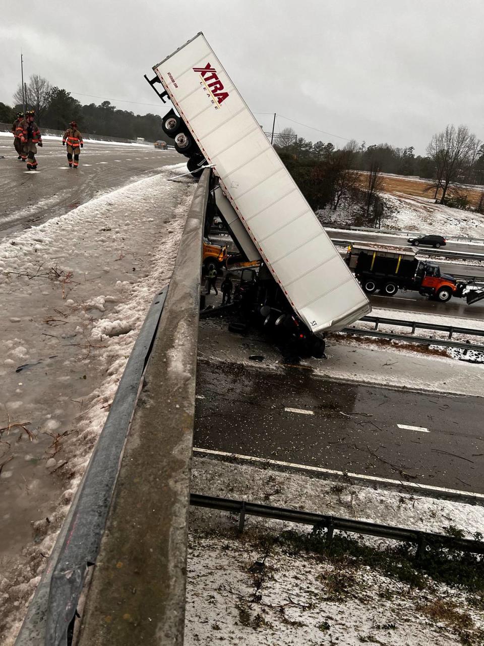 A tractor-trailer appears to have slid off an overpass in Durham, falling onto a highway below, during wet, slick road conditions as a result of hours of freezing rain and sleet from a winter storm on Sunday, Jan. 16, 2021.