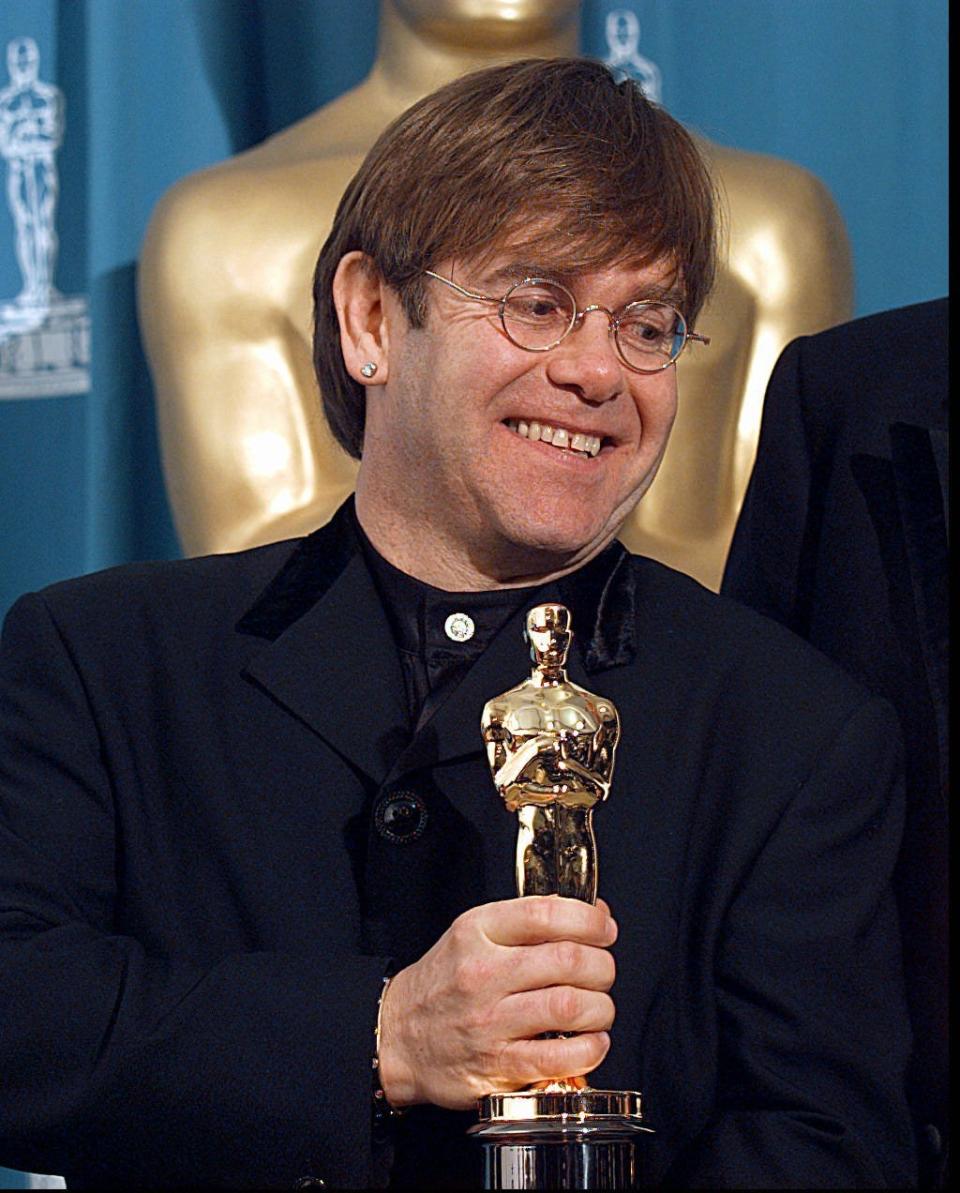 Elton John in 1995, holding his best original song Oscar for "Can You Feel the Love Tonight" from "The Lion King."