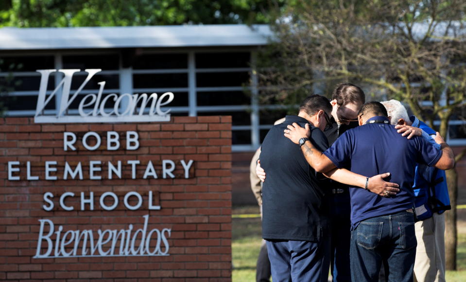 People gather at Robb Elementary School , the scene of a mass shooting in Uvalde, Texas, U.S. May 25, 2022. REUTERS/Nuri Vallbona