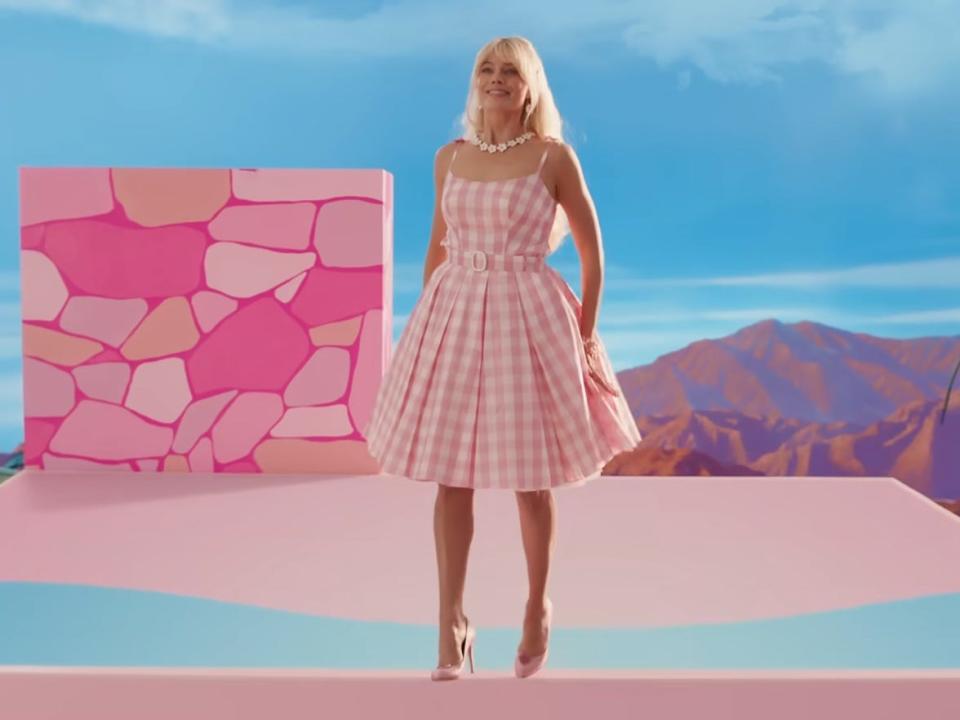 Margot Robbie in 'Barbie' wearing a pink gingham dress.