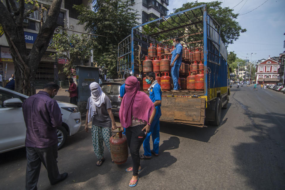MUMBAI, INDIA - MARCH 23: People carry gas cylinder during lockdown due to Covid 19 pandemic at Girgaum, on March 23, 2020 in Mumbai, India. (Photo by Pratik Chorge/Hindustan Times via Getty Images)