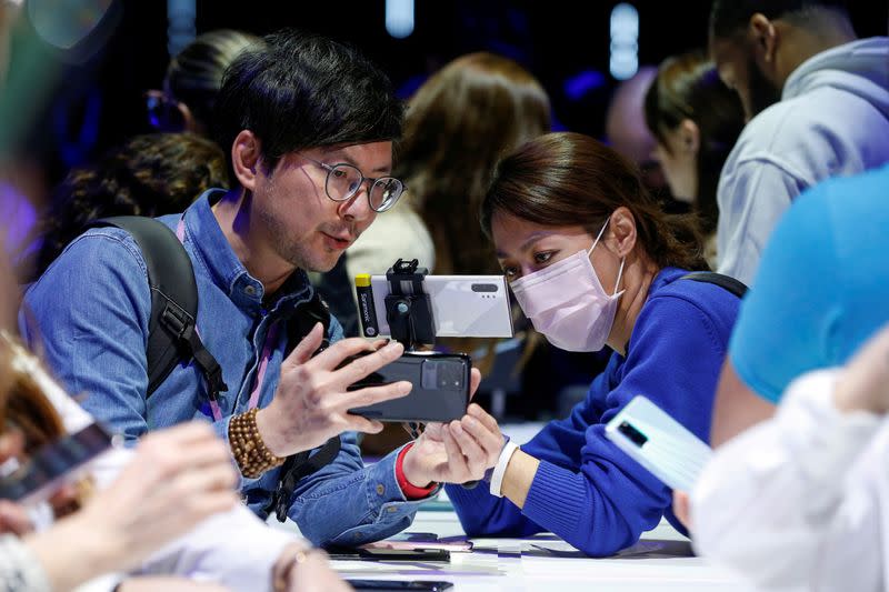 FILE PHOTO: Attendees look at a Samsung Galaxy S20 Ultra 5G smartphone during Samsung Galaxy Unpacked 2020 in San Francisco