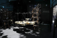 A man prepares the terrace of a restaurant in Paris, Monday, June 1, 2020, as France gradually lifts its Covid-19 lockdown. France is reopening tomorow its restaurants, bars and cafes as the country eases most restrictions amid the coronavirus crisis. (AP Photo/Christophe Ena)