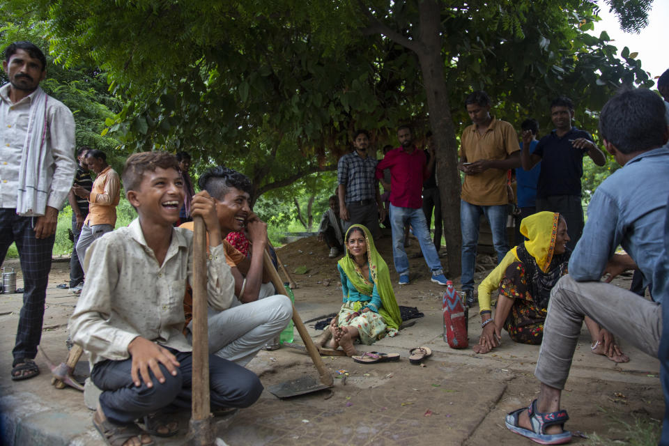 People from India's northern states wait at labor chowk - a bazaar at the junction of four roads where hundreds of workers gather daily at daybreak to plead for work in Manesar Industrial Area, Haryana state, India, Aug. 4, 2022. Scenes like this are an everyday reality for millions of Indians, the most visible signs of economic distress in a country where raging unemployment is worsening insecurity and inequality between the rich and poor. (AP Photo/Bhumika Saraswati)