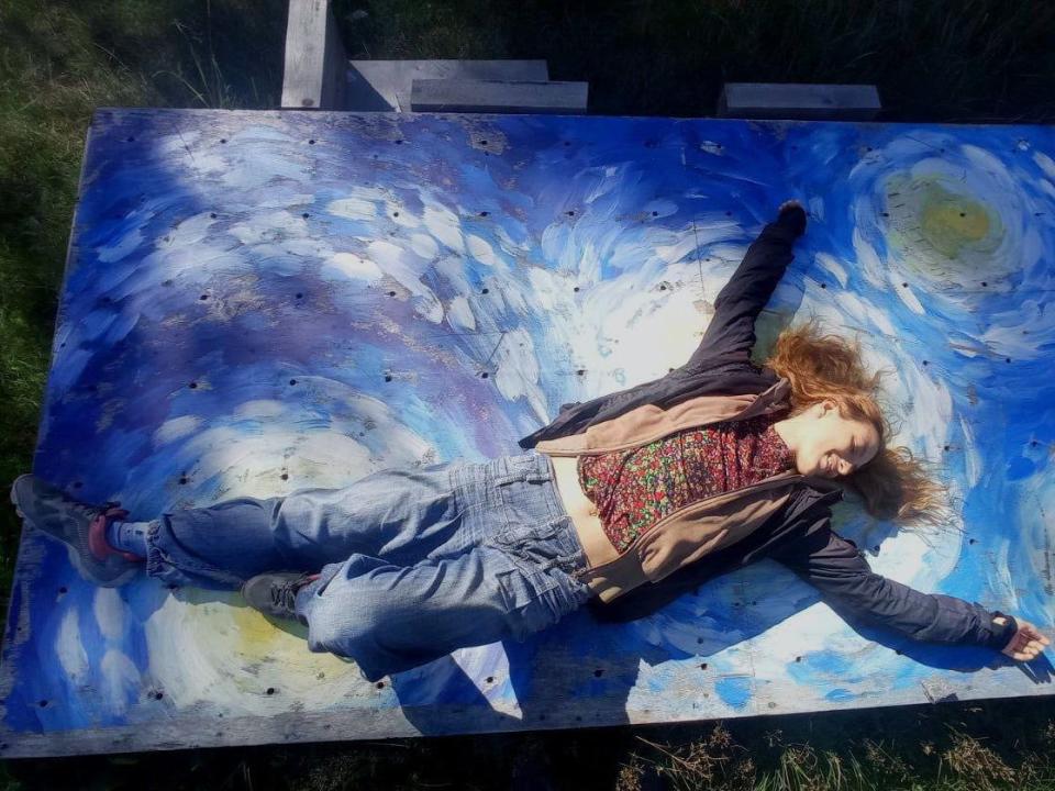 Alexandra Skochilenko lies on a painted canvas.