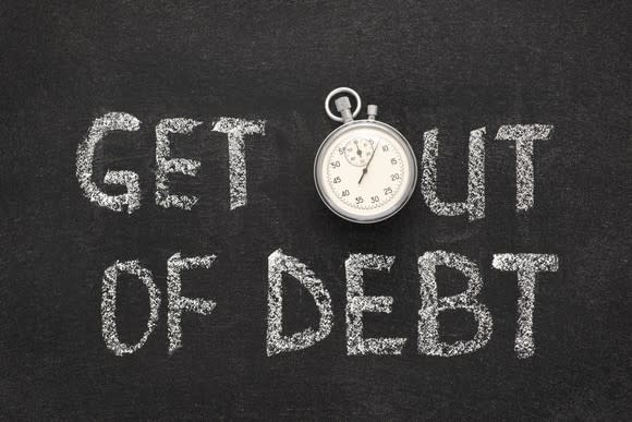 get out of debt written on a blackboard, with the o represented by a stopwatch