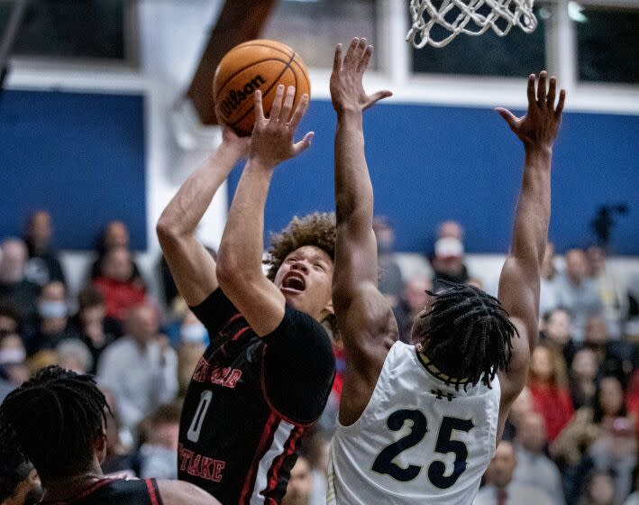 Sherman Oaks, CA - January 18: Harvard-Westlake High School point guard Trent Perry, center, shoots over Notre-Dame High School point guard Mercy Miller during the second half at Notre Dame High School in Sherman Oaks, Wednesday, Jan. 18, 2023. Harvard-Westlake won 85-78 after two overtimes. (Allen J. Schaben / Los Angeles Times)