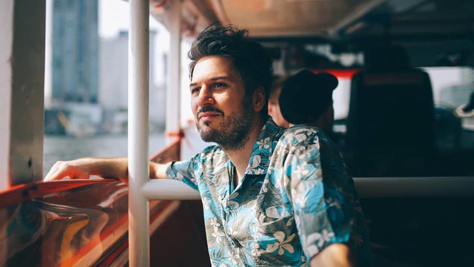 man looks out the window of tour bus