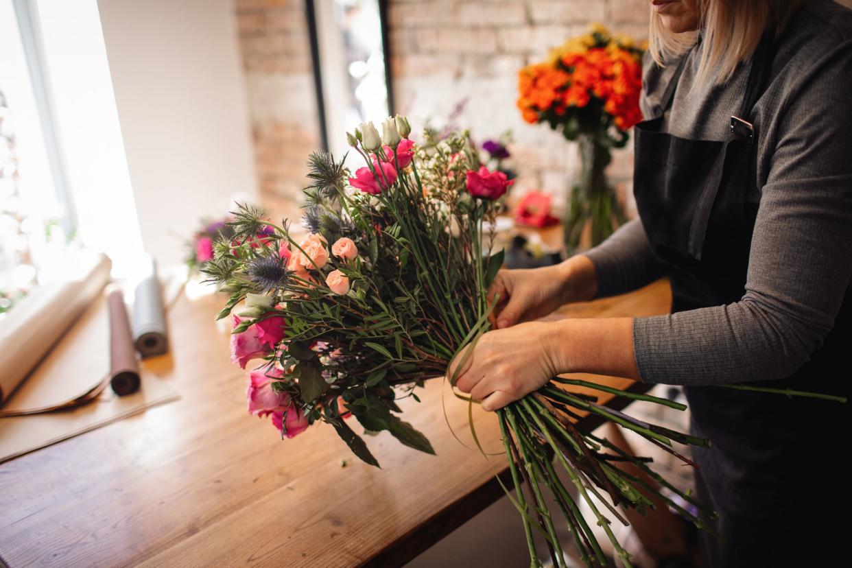 Female florist arranging bouquet in her flower shop