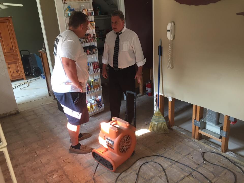 Howell homeowner Bob Saloman shows Congressman Chris Smith his flooded kitchen.