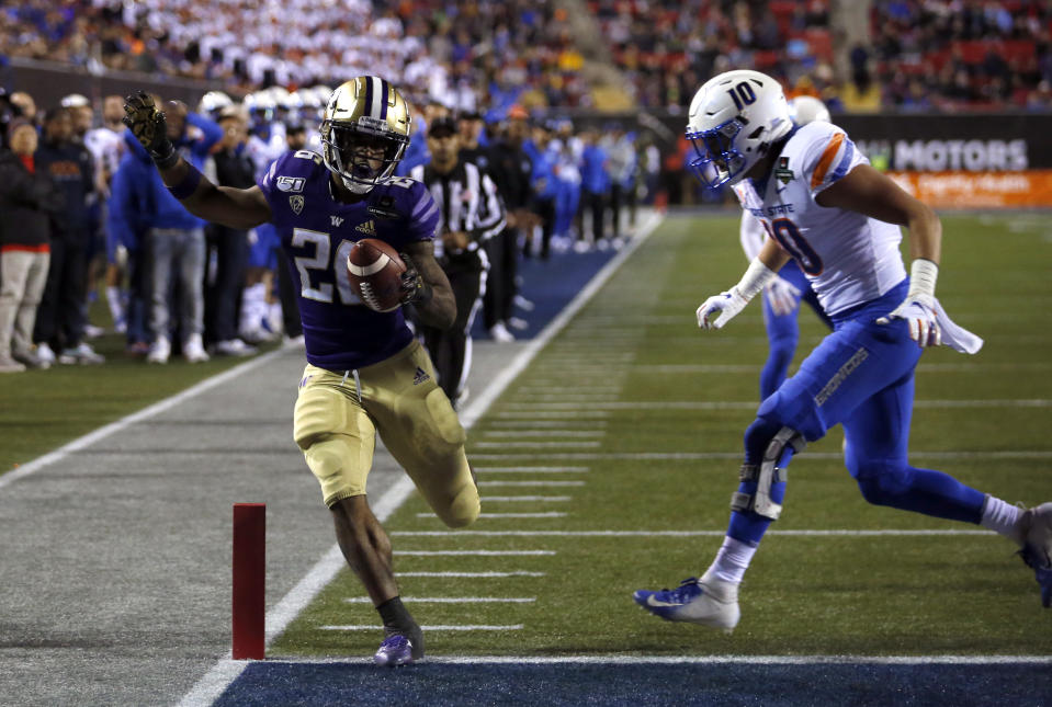 Washington running back Salvon Ahmed, left, makes it into the end zone ahead of Boise State safety Kekoa Nawahine for Washington's second touchdown during the first half of the Las Vegas Bowl NCAA college football game at Sam Boyd Stadium, Saturday, Dec. 21, 2019, in Las Vegas. (AP Photo/Steve Marcus)