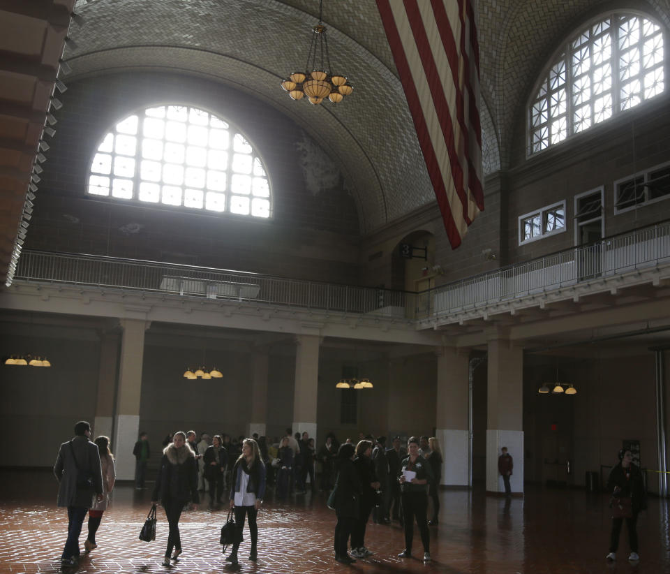 Visitors walk through the registry room at Ellis Island in New York, Monday, Oct. 28, 2013. The island that ushered millions of immigrants into the United States received visitors Monday for the first time since Superstorm Sandy. Sandy swamped boilers and electrical systems and left the 27.5-acre island without power for months. (AP Photo/Seth Wenig)