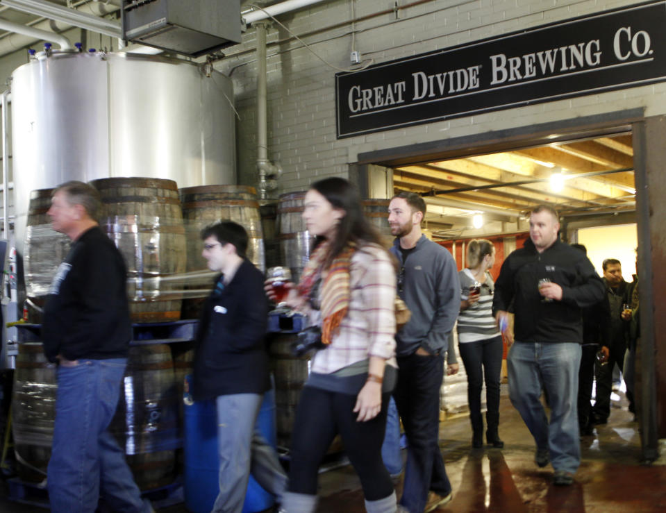 This photo taken on Dec. 7, 2012 shows a tour group walking through the Great Divide Brewery in Denver. A short walk from the 16th Street Mall: a sample of makers of beloved, homegrown Colorado craft beer. Wynkoop Brewing Co., co-founded by Gov. John Hickenlooper, and Great Divide Brewing Co. offer free tours of their downtown operations. (AP Photo/Ed Andrieski)