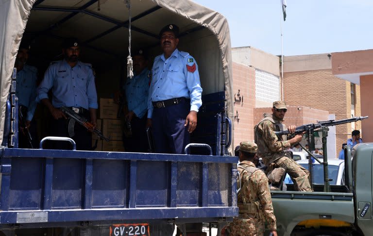 Pakistani policemen guard ballot boxes inside a truck before unloading while army soldiers keep vigil at an electoral materials distribution centre in Islamabad on May 10, 2013. Bombs exploded near party political offices in remote areas of Pakistan on Friday, killing four people on the eve of a landmark general election threatened by the Taliban with suicide attacks