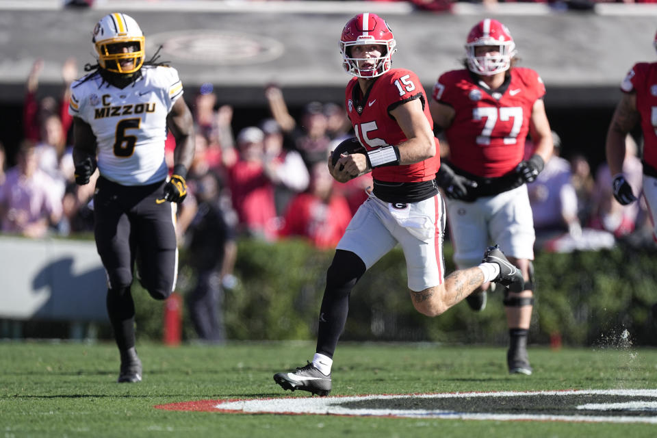 Georgia quarterback Carson Beck (15) scrambles as Missouri defensive lineman Darius Robinson (6) gives chase during the first half of an NCAA college football game, Saturday, Nov. 4, 2023, in Athens, Ga. (AP Photo/John Bazemore)