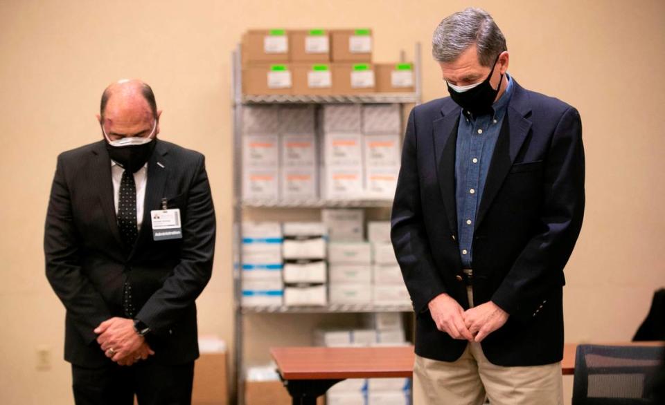 Donald Gintzig, WakeMed President & CEO, and North Carolina Governor Roy Cooper observe a moment of silence on the one year anniversary of the first diagnosed case of COVID-19 in North Carolina on Wednesday, March 3, 2021 at WakeMed in Raleigh, N.C. Moments later Governor Cooper received his COVID-19 vaccination.