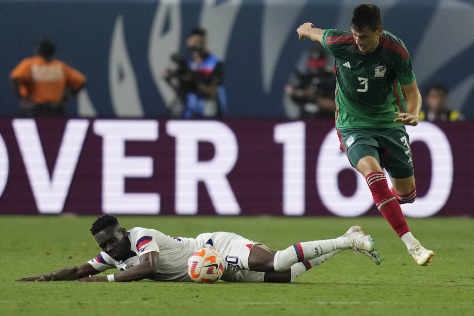 Folarin Balogun of the United States falls to the pitch against Cesar Montes of Mexico during the first half of a CONCACAF Nations League semifinal soccer match Thursday, June 15, 2023, in Las Vegas. (AP Photo/John Locher)