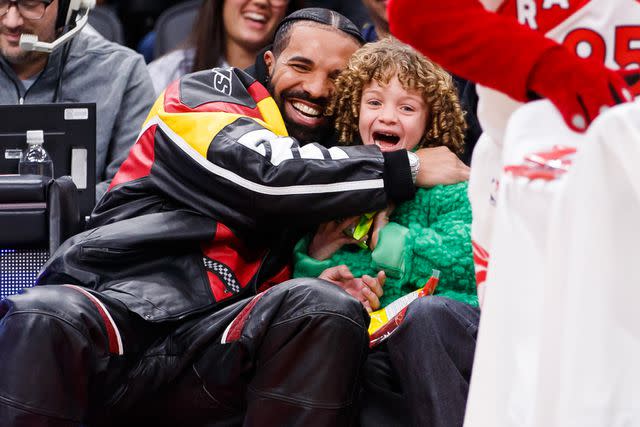 Cole Burston/Getty Drake hugs his son Adonis as the Raptor mascot brings him candy