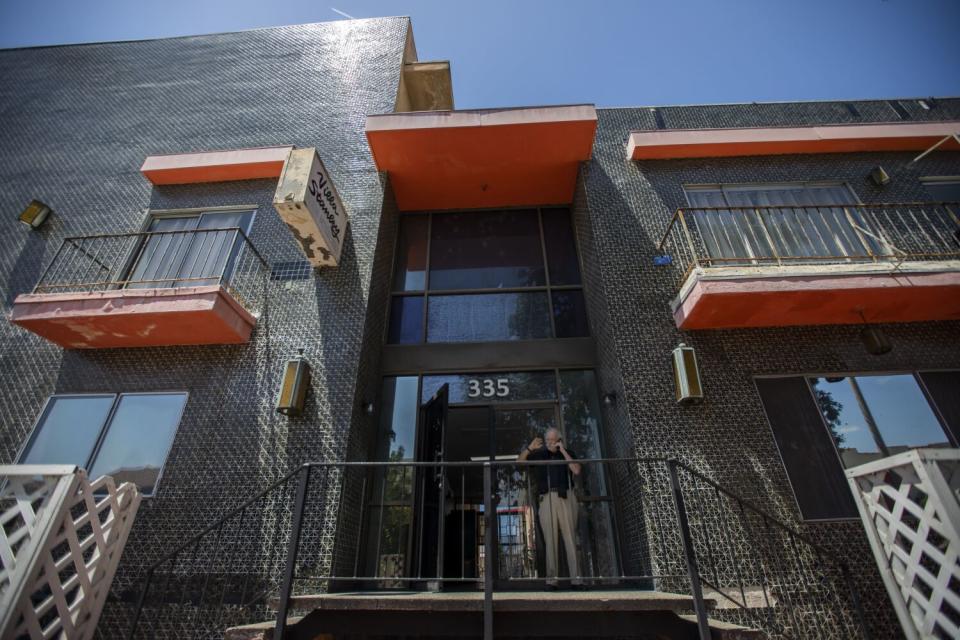 A person stands at the entrance to a building.