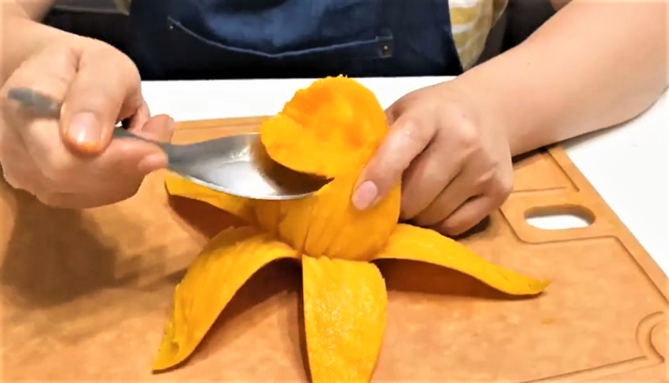 在芒果畫4、5刀，就可以像香蕉般剝下果皮。