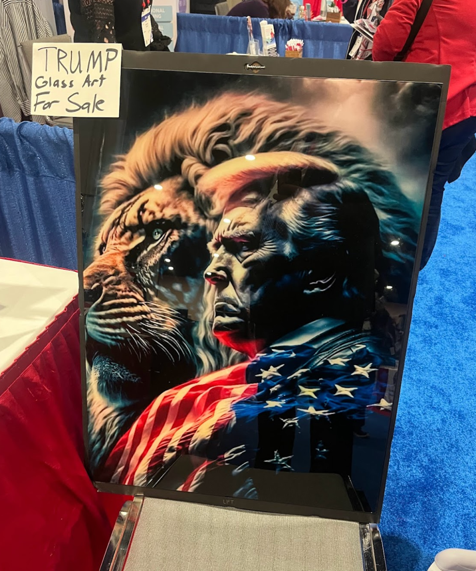 Donald Trump looks ahead next to a lion in a painting being sold at CPAC (Gustaf Kilander / The Independent)