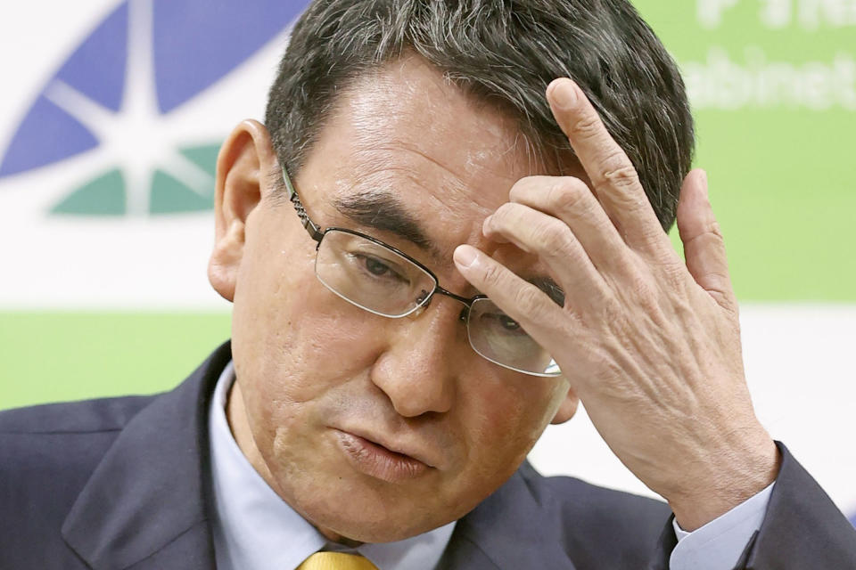 Japan's COVID-19 Vaccine Minister Taro Kono scratches his forehead during a press conference on coronavirus vaccination, in Tokyo Wednesday, June 23, 2021. Kono abruptly announced a temporary suspension of all reservations for mass inoculations, saying vaccine distribution cannot keep pace with demand. He described the situation as “being on a tightrope.” (Kyodo News via AP)