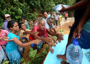 <p>Sri Lankan flood victims receive drinkable water bottles by Sri Lankan Navy soldiers at Godagama, Matara, southern part of Sri Lanka, May 30, 2017. (Tharaka Basnayaka/NurPhoto via Getty Images) </p>