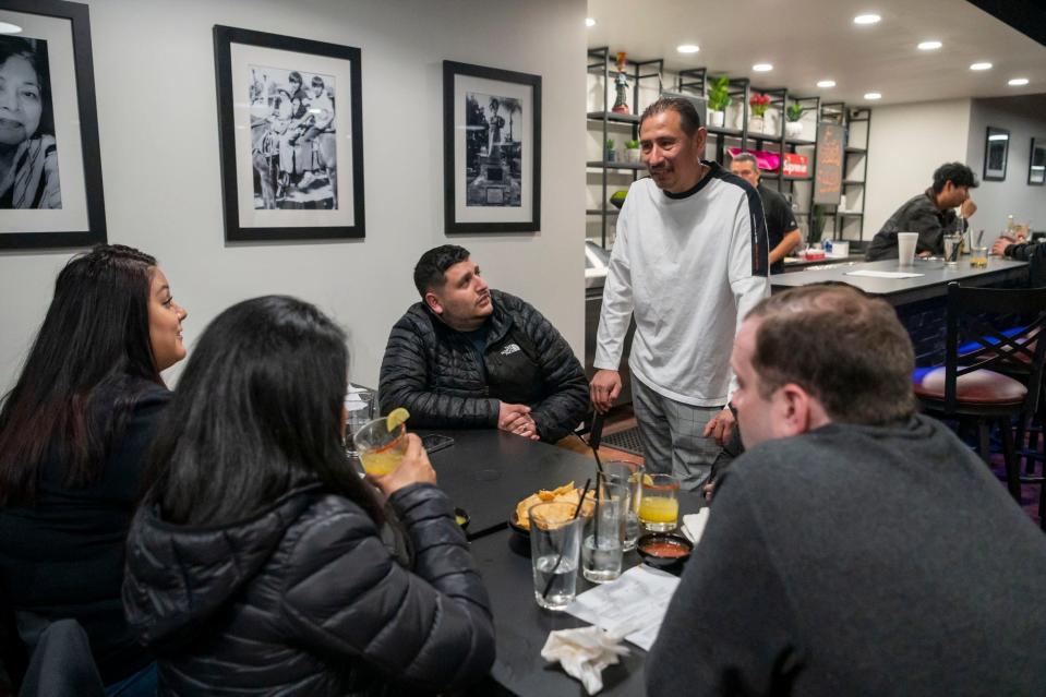 Javier Fortoso hangs out with friends and family during a soft opening at Torti Taco Bar and Grill in downtown Battle Creek on Feb. 19, 2022.