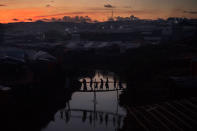 <p>People cross a bamboo bridge over a stream as the sun sets on October 13, 2017 at the Kutuplaong refugee camp, Cox’s Bazar, Bangladesh. (Photograph by Paula Bronstein/Getty Images) </p>