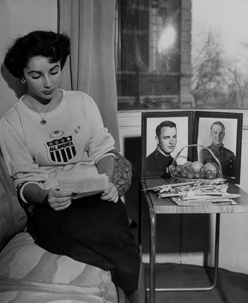 <p>Elizabeth is seen reading a letter from her overseas boyfriend, Glenn Davis, next to a portrait of him. The young couple broke up later that year. </p>