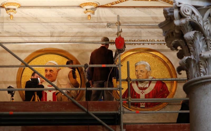 FILE PHOTO: Workers install a mosaic depicting Pope Francis next to the one depicting Pope Emeritus Benedict XVI at Saint Paul's Basilica in Rome