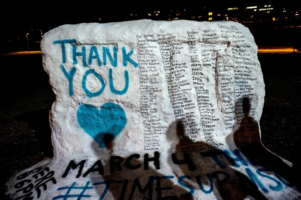 Shadows of Michigan State University students appear on “the rock” in the university campus which was painted “Thank You” and includes the names of the women who gave victim impact statements during the Larry Nassar sexual assault sentencing hearing. (AP)