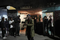 Rap artist Roque competes at the Gas Battle rap competition outside a bar in the City of God favela of Rio de Janeiro, Brazil, late Wednesday, Nov. 10, 2021. Rap artists in the favela are starting to compete again since the COVID-19 pandemic curtailed public gatherings, presenting local residents with a show in a sign of a return to normalcy for music lovers. (AP Photo/Silvia Izquierdo)