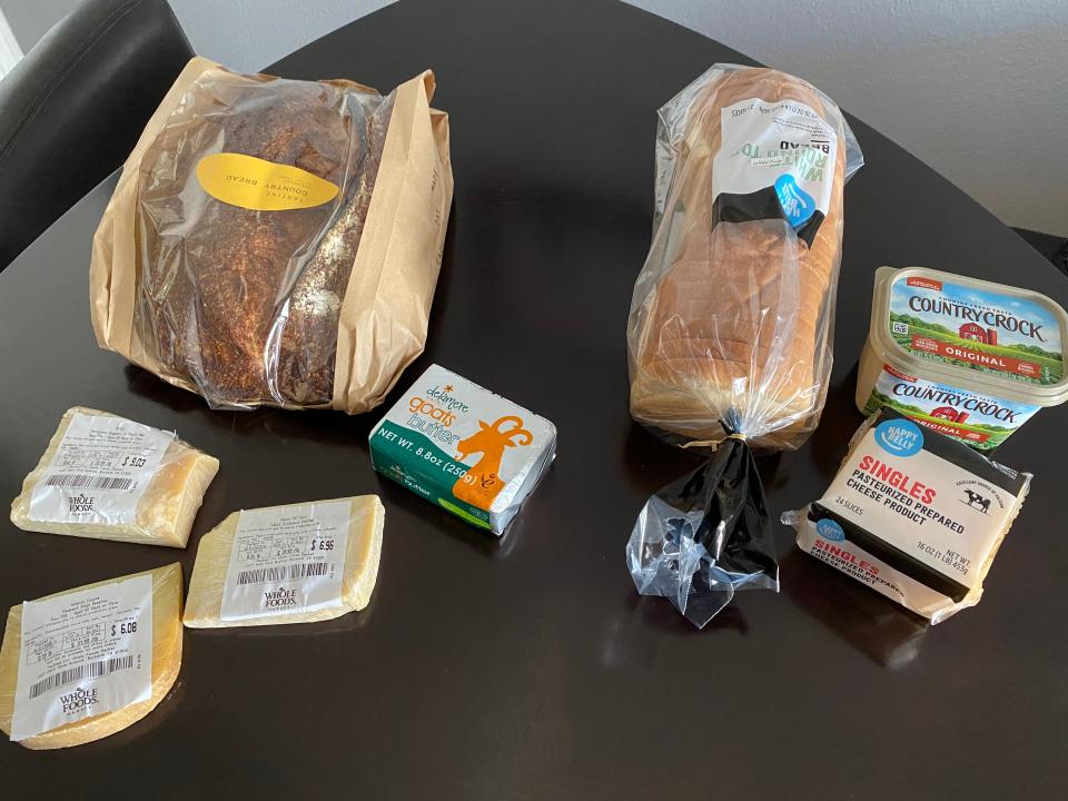 two sets of bread, cheese, and butter sitting on a kitchen table
